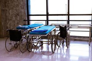 cadeira de rodas e cama na área hospitalar foto