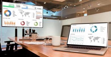apresentação de slides em exibição de laptop e televisão com xícara de café na mesa na sala de reuniões foto