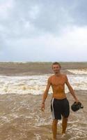 homem está na praia durante o furacão e gosta do méxico. foto