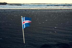 feche a bandeira da islândia na foto do conceito de praia de areia preta