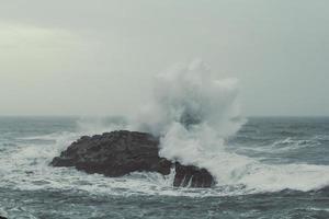 respingos de água sobre o penhasco na paisagem do mar photo foto