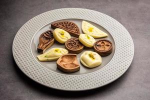 comida doce sandesh ou shondesh com moldes de madeira em um prato foto