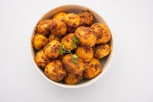 Batatas Bombay assadas caseiras. Batatinhas fritas ou aloo com sementes de jeera e coentro em tigela foto