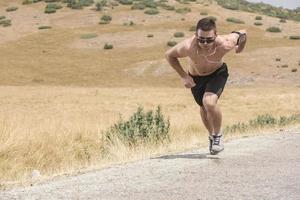 corredor de homem desportivo correndo no planalto da montanha no verão foto