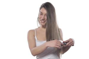 jovem mulher bonita com cabelos longos, penteando o cabelo pela manhã. conceito de cuidado de cabelo. foto