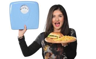 retrato de uma linda jovem engraçada no fundo branco, segurando um hambúrguer de bandeja com hambúrguer e escala de medição foto
