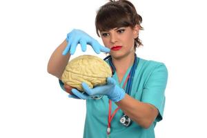 médica segurando um modelo de cérebro humano contra fundo branco foto