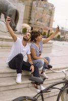 casal de turistas se divertindo andando na rua da cidade no feriado - amigos felizes rindo juntos nas férias - conceito de pessoas e feriados foto