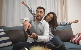casal sorridente feliz jogando videogame em casa. foto