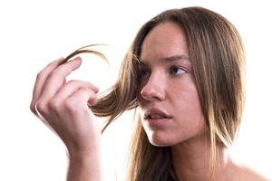 atraente bela modelo feminino segurando o cabelo dela. isolado no fundo branco foto