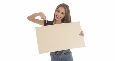 menina sorridente segurando a placa em branco. retrato de estúdio de jovem com cartão de sinal. isolado. foto