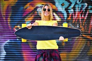 mulher legal de skate em um parque público de graffiti foto