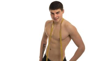 modelo masculino com grande corpo medindo seu corpo com fita métrica foto