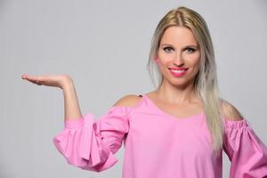 retrato de mulher jovem e bonita em camisa rosa bonita e jeans azul posando no estúdio. conceito de beleza, emoções, expressão facial, estilo de vida, moda, cultura jovem foto