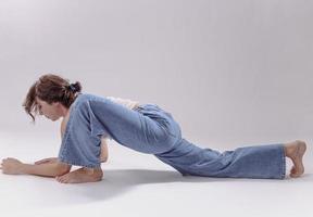 retrato de mulher jovem e bonita com corpo flexível atlético fazendo alongamento de perna. isolado foto