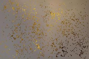 confete de glitter dourado sobre fundo cinza. partículas brilhantes, pano de fundo abstrato decorativo. festa, feliz natal, feliz ano novo. foto