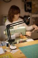 mulher costurando tecido com uma máquina de costura retrô vintage. moda, criação e alfaiataria. processo de costura em atelier ou oficina. passatempo especial. foto