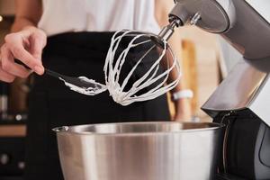 mulher usando processador de alimentos para cozinhar na cozinha foto