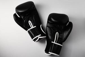 par de luvas de boxe pretas sobre fundo branco, closeup foto