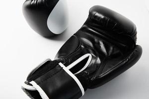 par de luvas de boxe pretas sobre fundo branco, closeup foto