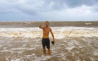 homem está na praia durante o furacão e gosta do méxico. foto