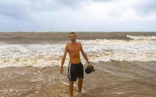 homem está na praia durante o furacão e gosta do méxico. foto