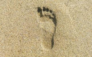 pegada pegadas na areia da praia perto da água méxico. foto