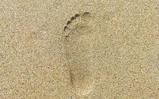 pegada pegadas na areia da praia perto da água méxico. foto