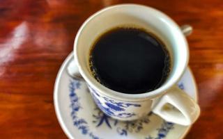 pote de xícara branca azul com mesa de madeira de café preto méxico. foto