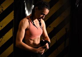 close-up de uma mulher fazendo bandagens de boxe em uma gaiola de luta foto