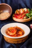 camarão com molho de pimenta vermelha no prato. camarão balado . comida indonésia foto