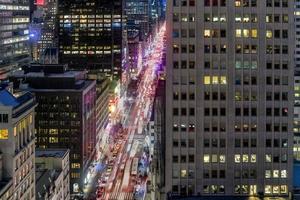 o horizonte da cidade de nova york no centro de manhattan enquanto os carros atravessam a cidade à noite. foto