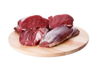 carne de bovino crua e placa de corte isolada no fundo branco foto