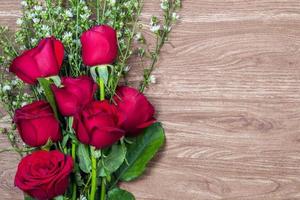 um buquê de rosas em um fundo de padrão de madeira foto