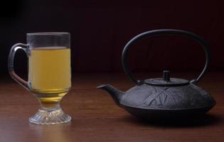 bule de chá de ferro fundido com uma xícara de chá foto