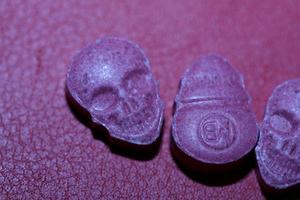pílula de êxtase de caveira rosa fechar fundo impressão de alta qualidade roxo exército droga narcóticos substância alta dose psicodélica modo de vida foto