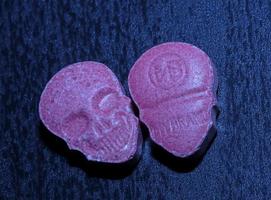pílula de êxtase de caveira rosa fechar fundo impressão de alta qualidade roxo exército droga narcóticos substância alta dose psicodélica modo de vida foto
