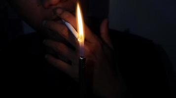 fumante acendendo um cigarro com um isqueiro a gás. foto