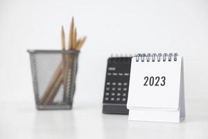 Calendário de negócios de 2023 e lápis na mesa de escritório no dia de ano novo. fazer um plano de trabalho para o início do ano. conceito sobre celebração, negócios, natal, ano novo. foto