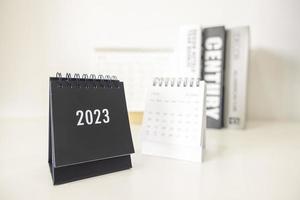 Calendário de negócios de 2023 na mesa de escritório no dia de ano novo. fazer um plano de trabalho para o início do ano. conceito sobre celebração, negócios, natal, ano novo. foto