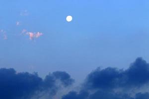 lua e nuvens no céu sobre o mar foto