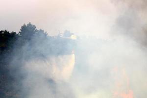 um helicóptero apaga um incêndio florestal nas montanhas do norte de israel. foto