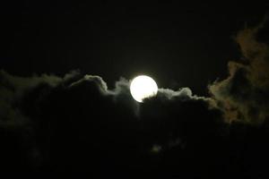 lua e nuvens no céu sobre o mar foto