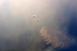 um helicóptero apaga um incêndio florestal nas montanhas do norte de israel. foto