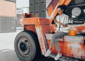 retrato do engenheiro industrial mulher multirracial no capacete trabalhando no armazém de contêineres logísticos. inspetor ou supervisor em colete de segurança é responsável pelo armazenamento de carga e comércio global de entrega foto