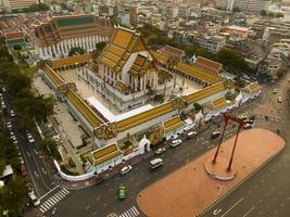 uma vista aérea do balanço do gigante vermelho e do templo suthat thepwararam na cena do pôr do sol, a atração turística mais famosa de bangkok, tailândia foto