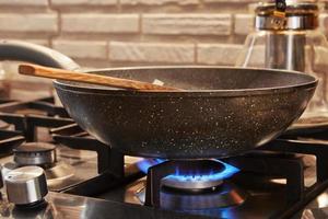 frigideira no fogão a gás pegando fogo com prato sendo preparado foto