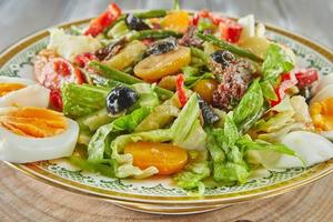 gourmet de cozinha francesa de salada niçoise, em fundo de madeira foto