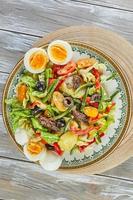 gourmet de cozinha francesa de salada niçoise, em fundo de madeira foto