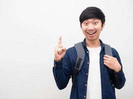 homem asiático com mochila escolar sorriso rosto apontar dedo para cima ter ideia retrato cópia espaço fundo branco foto